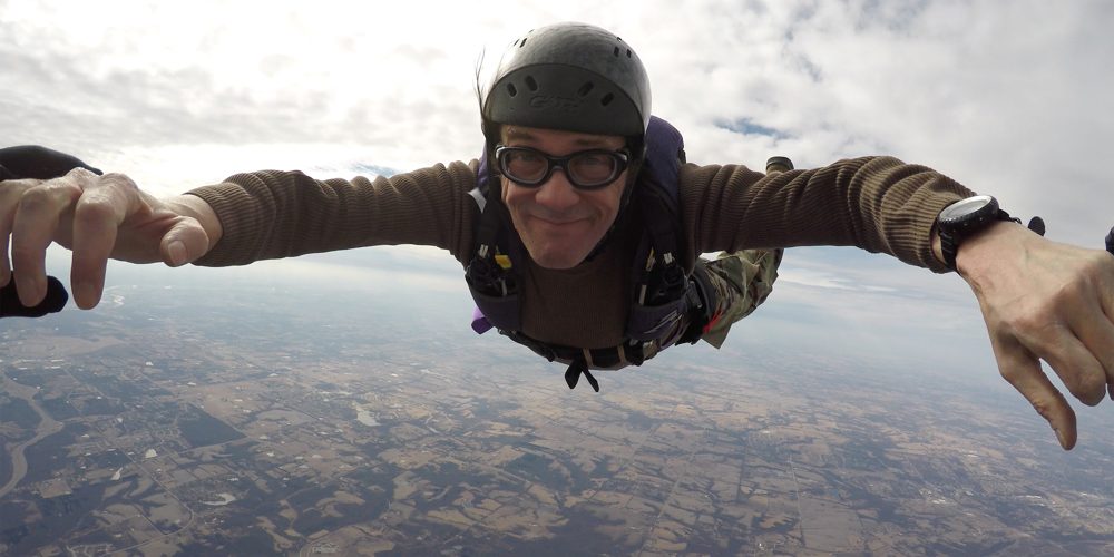 Dr. Kevin J. Payne in freefall, arms spread, facing the camera