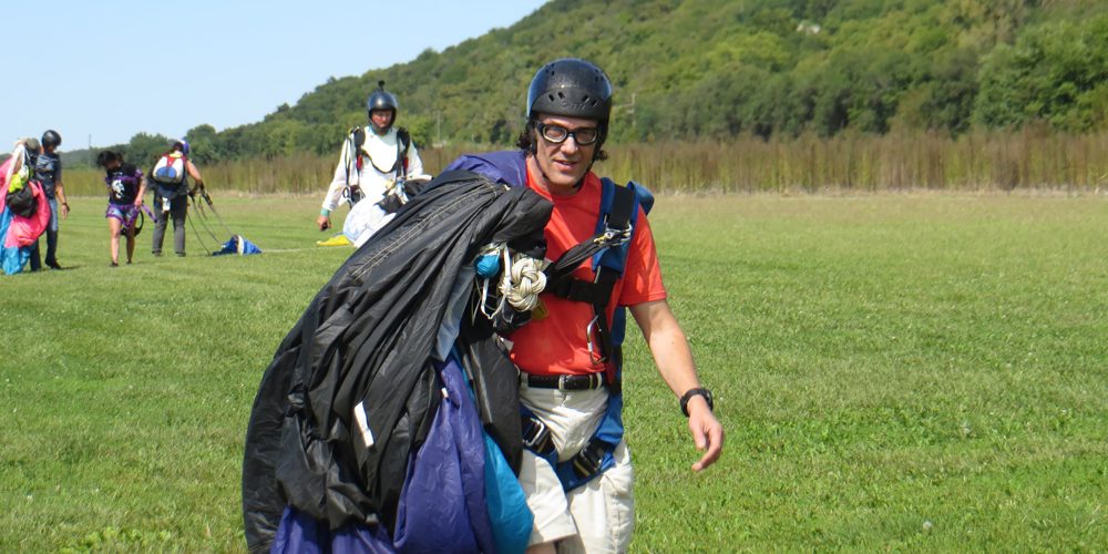 Dr. Payne walking in from the landing area carrying his canopy