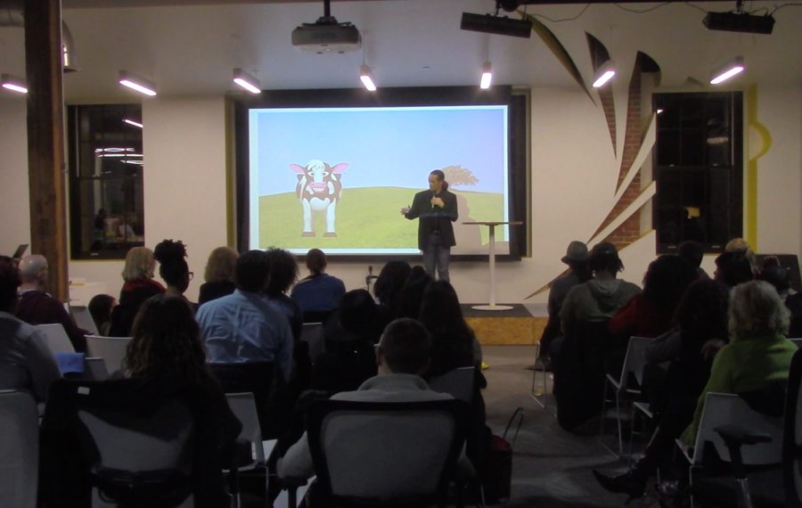 Dr. Payne presenting to a full room in front of a projected slide
