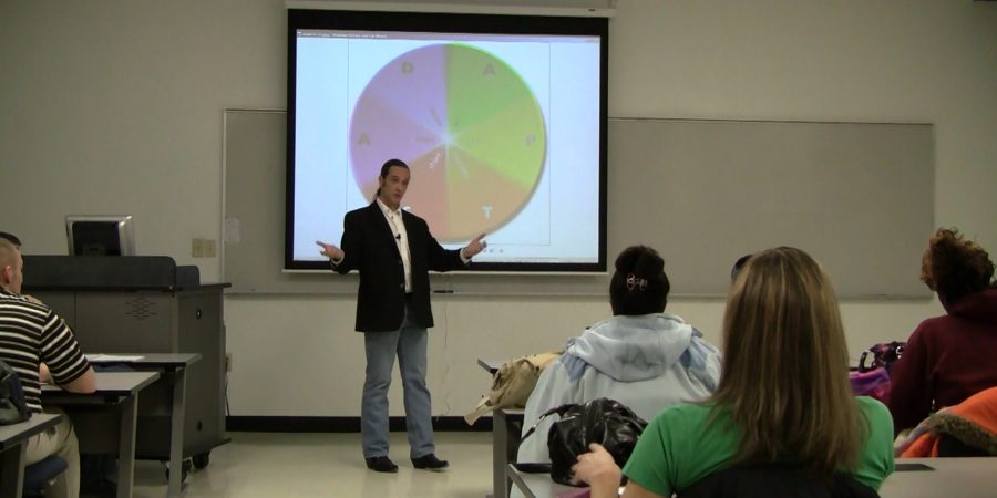 Dr. Payne teaching a class in front of a projected slide