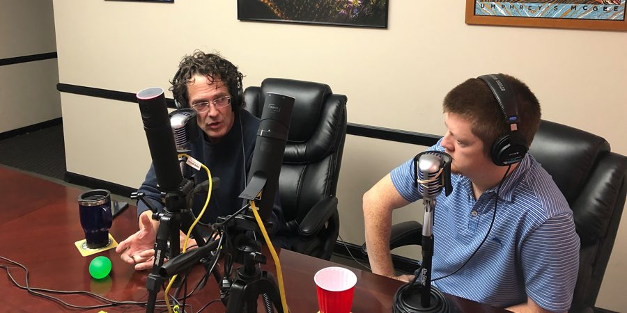 Dr. Payne in headphones at a broadcast microphone beside the host